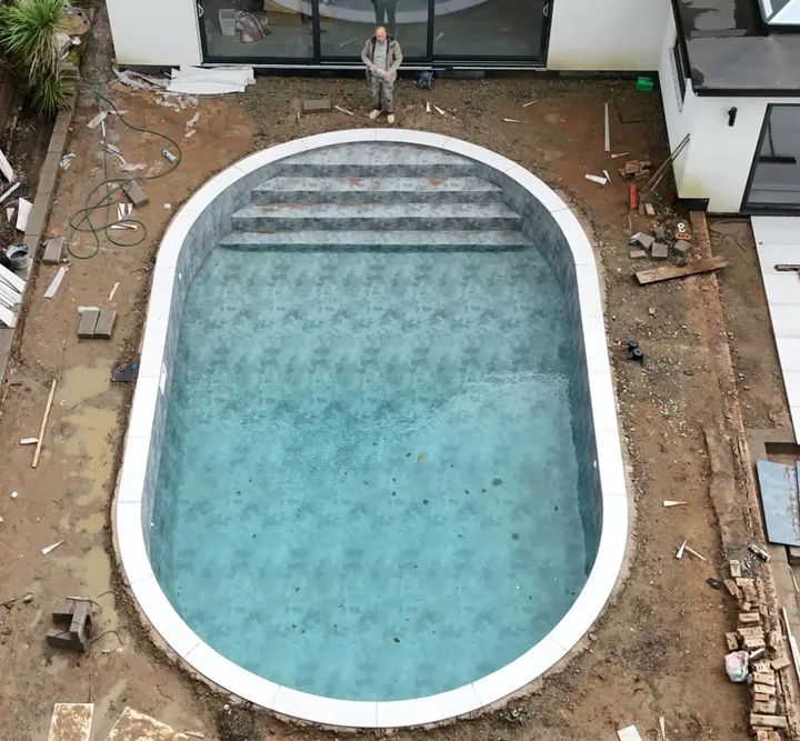 Aerial view of a curved porcelain pool coping run with a full bullnose edge