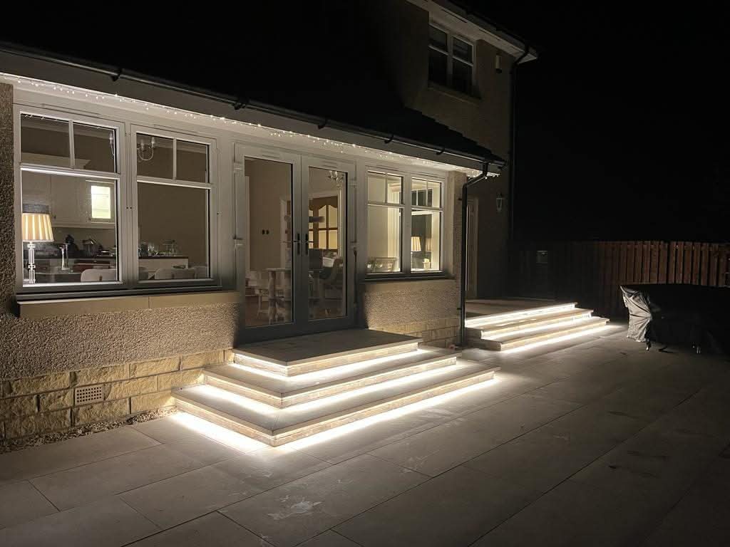 LED-lit natural stone garden steps with bullnose copings at night