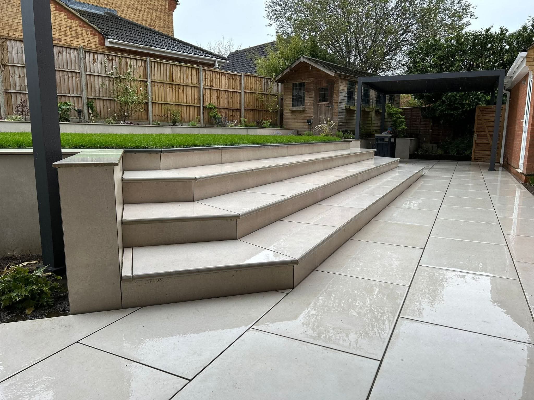 Porcelain garden steps and patio beneath a pergola in a residential garden