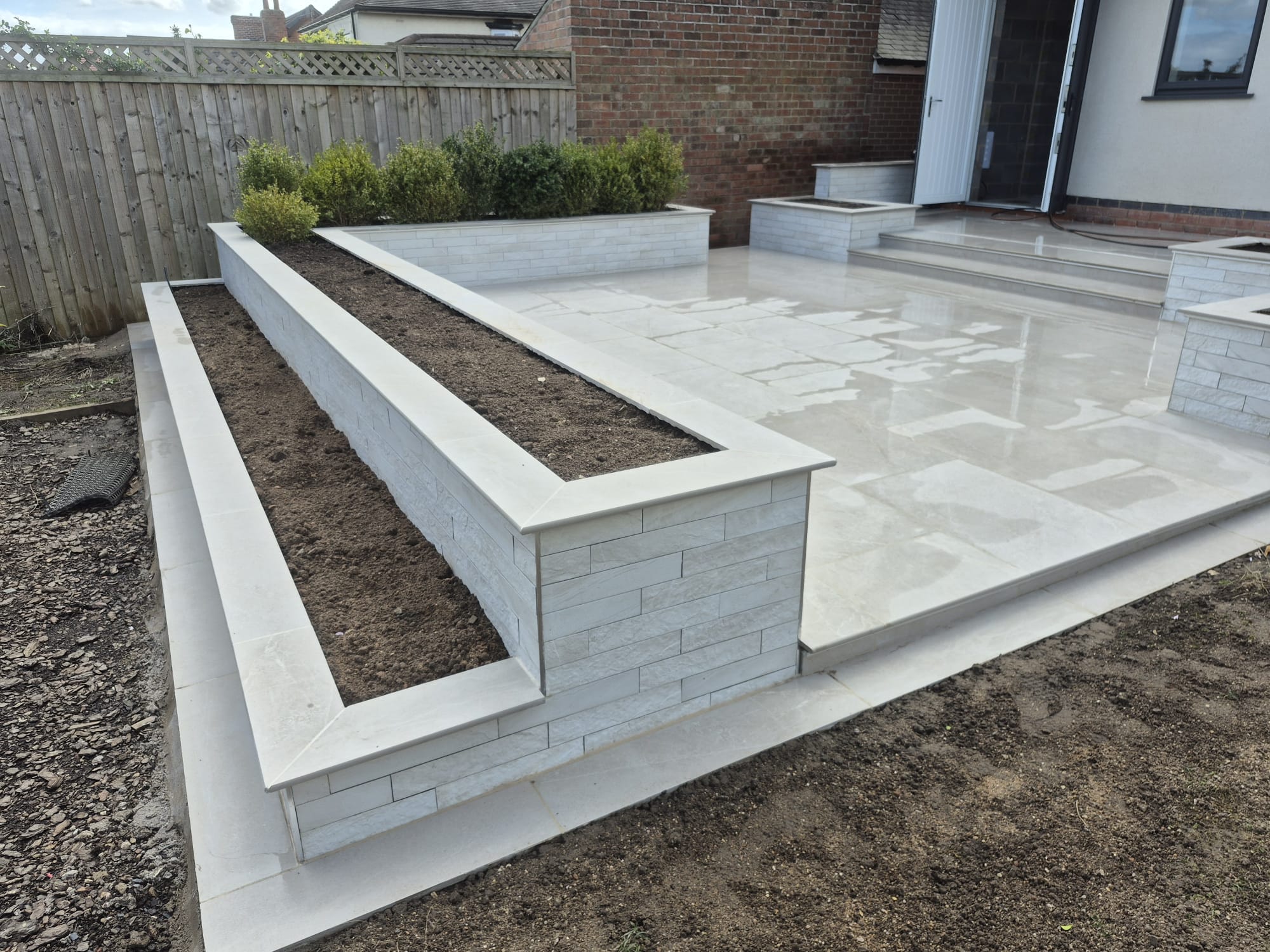 Porcelain-capped planter walls on a patio, cut to bespoke sizes