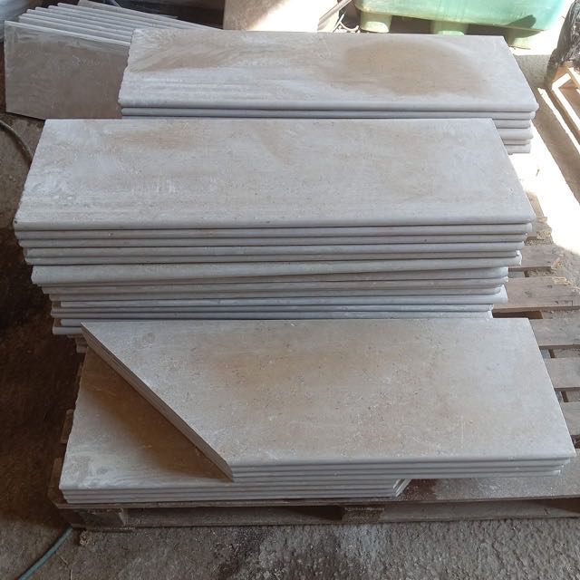 Bullnosed stone pool copings stacked on a pallet