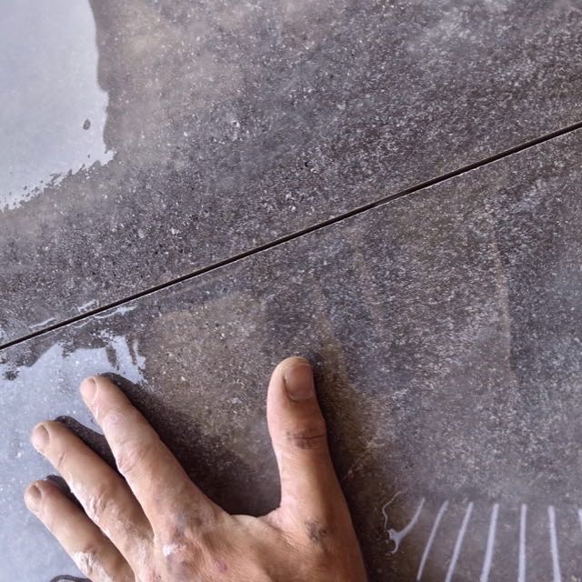 Close-up of a precision mitred joint on dark grey tile