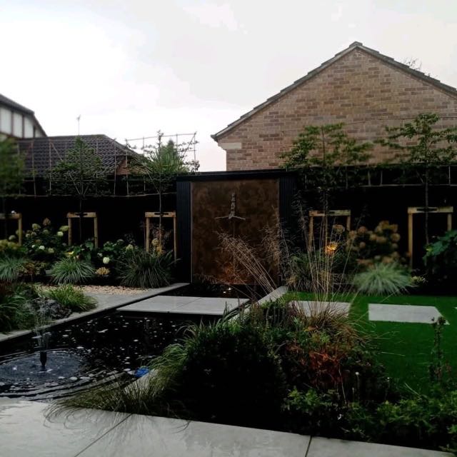 Garden porcelain paving beside a pond and water feature