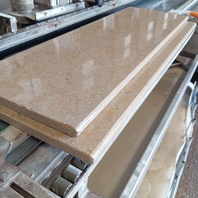 Polished bullnose stone coping on the profiling machine