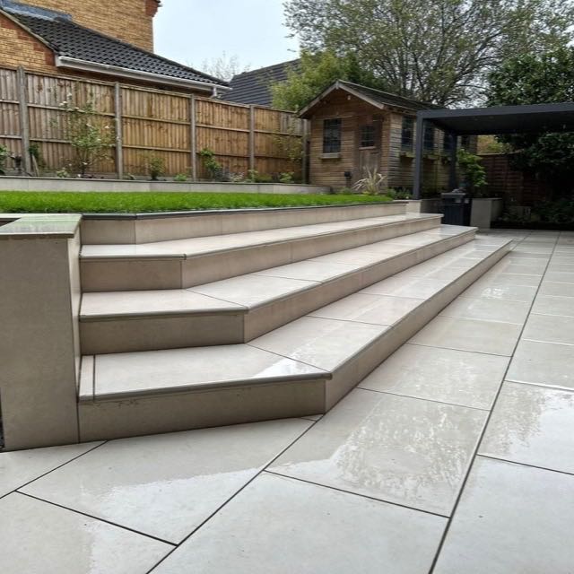 Porcelain garden steps and patio beneath a pergola
