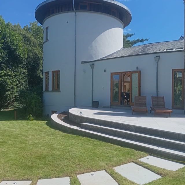 Curved stone terrace and steps at a round tower house
