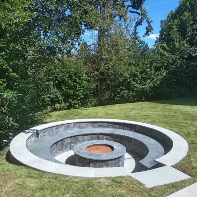 Sunken circular fire pit with a stone seating area