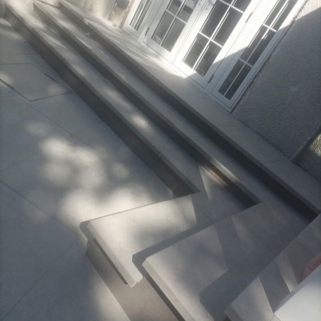 Wraparound porcelain steps leading onto a patio